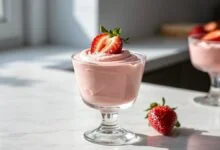 Taça elegante com mousse rosa aveludado decorado com morangos