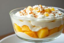 Travessa de vidro mostrando as camadas perfeitas de creme, biscoito e abacaxi