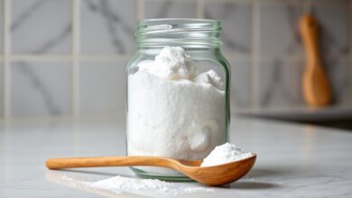 Um pote de vidro com açúcar impalpável caseiro, branco, fino e solto, pronto para uso em receitas de confeitaria.