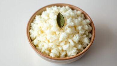 Tigela de arroz branco soltinho e perfumado, com folhas de louro e um brilho de azeite.