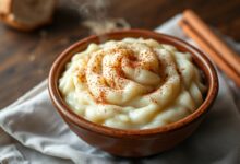 Tigela de arroz doce cremoso, denso e aveludado, com um leve toque de canela e grãos macios, servido em uma tigela de cerâmica rústica.