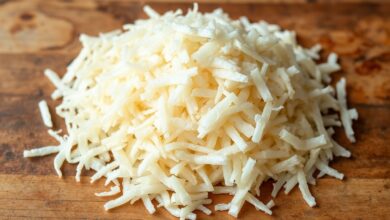 Lascas claras e uniformes de bacalhau desfiado à mão, prontas para serem usadas em receitas.