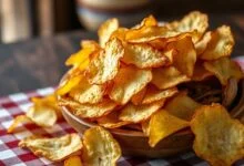 Travessa recheada de batatas chips douradas e estalando, prontas para servir.