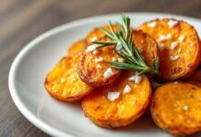 Fatias douradas de batata doce com bordas crocantes e interior macio, prontas para servir.