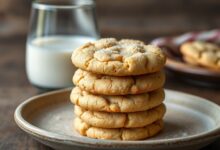 Pilha de biscoitos de leite dourados e farofentos, prontos para servir.