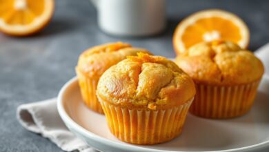 Bolinhos dourados e fofinhos, com raspas de laranja fresca, prontos para o café da tarde.