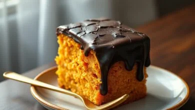 Bolo de cenoura alto com cobertura de chocolate que brilha e apresenta rachaduras crocantes