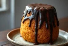 Bolo de cenoura alto e fofinho coberto com calda de chocolate brilhante e craquelada