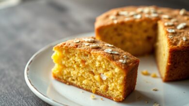 Bolo de milho fit inteiro e fatiado, dourado por cima, úmido por dentro, servido em um prato rústico.