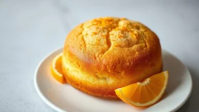 O bolo inteiro, dourado e fofinho, com raspas de laranja frescas por cima.