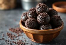 Vista de uma travessa com brigadeiros enrolados e granulados, prontos para servir.
