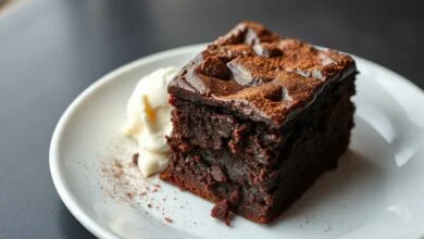 Fatia de brownie com textura úmida de fondant, casquinha craquelada e centro cremoso, servida em prato branco.