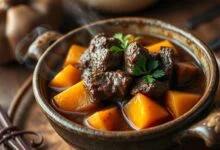 Prato de carne de panela com batata doce, com cubos de carne macia, caldo encorpado e batata doce laranja, servido em uma tigela de cerâmica rústica.
