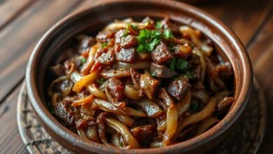 Carne seca acebolada com cebolas caramelizadas e salsinha fresca, pronta para servir.