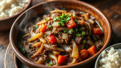 Carne seca desfiada e dourada, refogada com cebola grossa e tomate, finalizada com cheiro-verde fresco em um prato rústico.