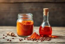 Potes de vidro exibindo o pó de colorau laranja vibrante e o óleo vermelho intenso