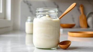 Pote de vidro com creme branco, liso e homogêneo, pronto para usar em sobremesas.