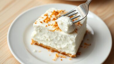 Fatia generosa de creme marido gelado em prato de porcelana branca, com textura firme e cremosa, coberta por lascas de coco tostado.