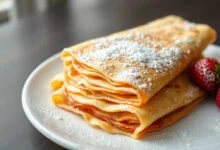 Pilha de crepes dourados, finos e macios, prontos para rechear.