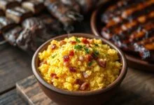 Tigela de barro rústica com farofa dourada, granulada e soltinha, com pedacinhos de bacon crocante e toques de salsinha fresca.