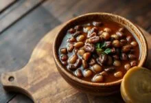 Uma tigela de feijão carioca perfeitamente temperado, com caldo encorpado e brilhante, demonstrando o resultado da técnica de dessalgamento.