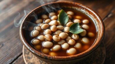 Uma tigela de feijão carioca perfeitamente cozido, com grãos inteiros e soltinhos, em um caldo espesso e aromático, pronto para servir.