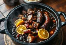 Uma panela gigante de feijoada com caldo escuro e brilhante, repleta de feijão preto macio, linguiça calabresa, costela e bacon, pronta para servir uma grande confraternização.