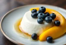 O flan cremoso desenformado e adornado com frutas frescas, pronto para servir.