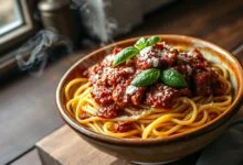 Um grande bowl de espaguete coberto por um molho bolonhesa rico e encorpado, com pedaços de carne visíveis e folhas de manjericão fresco.