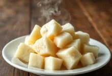 Pedaços de mandioca amarga perfeitamente cozidos, com casca removida, mostrando o interior branco e firme, prontos para o consumo.