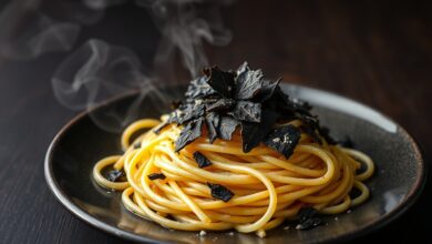 Espaguete al dente coberto com lâminas finíssimas de trufa negra e fio de azeite aromatizado, prato elegante sobre mesa de madeira escura.