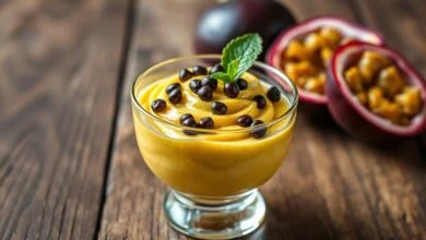 Taça elegante de mousse de maracujá vibrante e aerado, com as sementes pretas da fruta por cima.