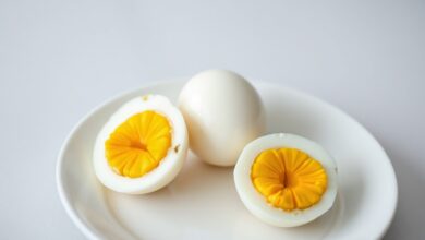 Três ovos cozidos perfeitamente descascados e cortados ao meio, expondo uma gema dura, firme e de um amarelo vibrante, sem o anel cinzento.