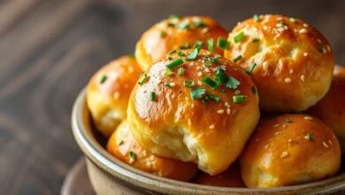 Rolinhos de pão de alho dourados e crocantes, com pedacinhos de salsinha e cebolinha visíveis, servidos em uma tigela de cerâmica rústica.