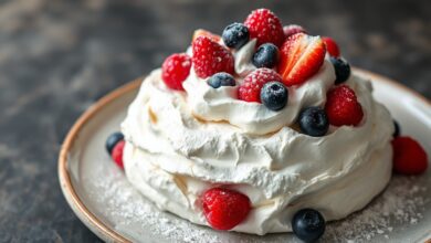 A pavlova finalizada, com sua casca branca e rachaduras, coroada por chantilly e frutas vermelhas vibrantes.