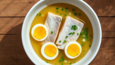 Prato reconfortante de postas de peixe firme em caldo dourado com ovos cozidos e cheiro-verde.