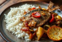 Peixe seco salgado desfiado e refogado com cebola e alho dourados no azeite, finalizado com pimenta dedo-de-moça, servido em prato de cerâmica rústico com arroz branco e farofa ao lado.