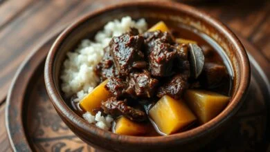 Carne desfiada em molho escuro com pedaços de mandioca dourada, servida em prato de cerâmica rústico