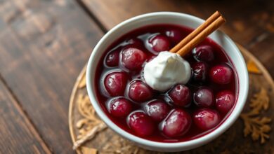 Tigela de sagu de vinho com grãos translúcidos vermelho-escuros, caldo encorpado e brilhante, finalizado com uma colherada de creme de leite branco ao lado