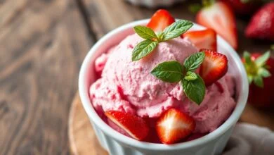 Tigela de sorvete caseiro de morango com cor rosa vibrante e textura aveludada, guarnecido com frutas frescas.