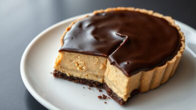 A torta inteira com a cobertura de ganache brilhante, fatiada para revelar o recheio cremoso e a base de biscoito.