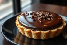 Torta de chocolate estruturada com cobertura de ganache brilhante e base crocante