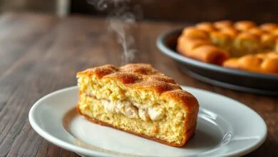 Fatia generosa de torta salgada dourada, mostrando o recheio cremoso de frango e a massa leve.