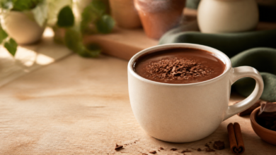 Caneca de chocolate quente cremoso com raspas de chocolate sobre mesa acolhedora