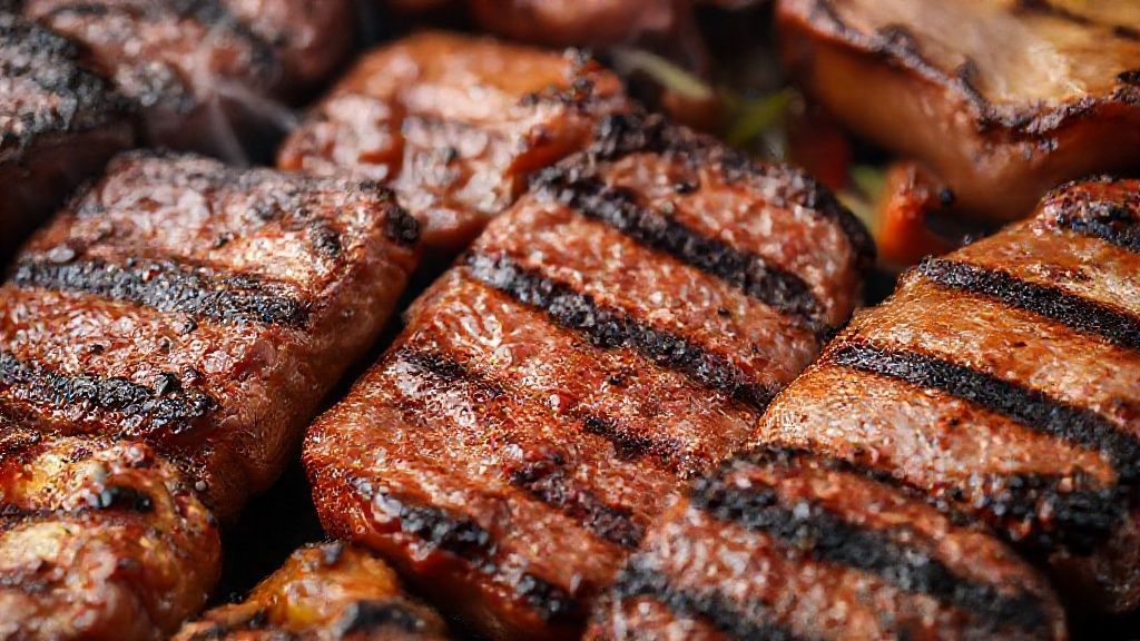 Close-up do churrasco finalizado com diferentes cortes suculentos prontos para servir