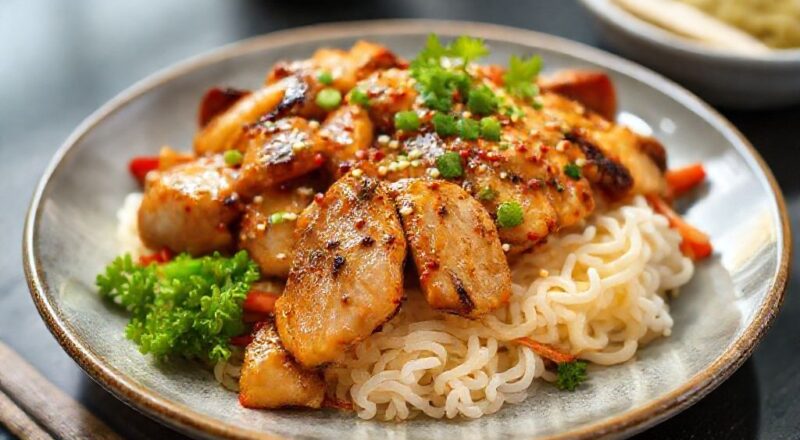 Prato de frango teriyaki finalizado, com molho brilhante, gergelim e arroz japonês, servido de forma sofisticada.