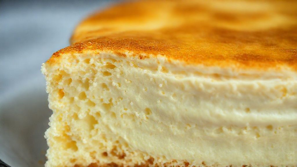 Close-up do bolo cortado mostrando o interior cremoso e a casquinha dourada